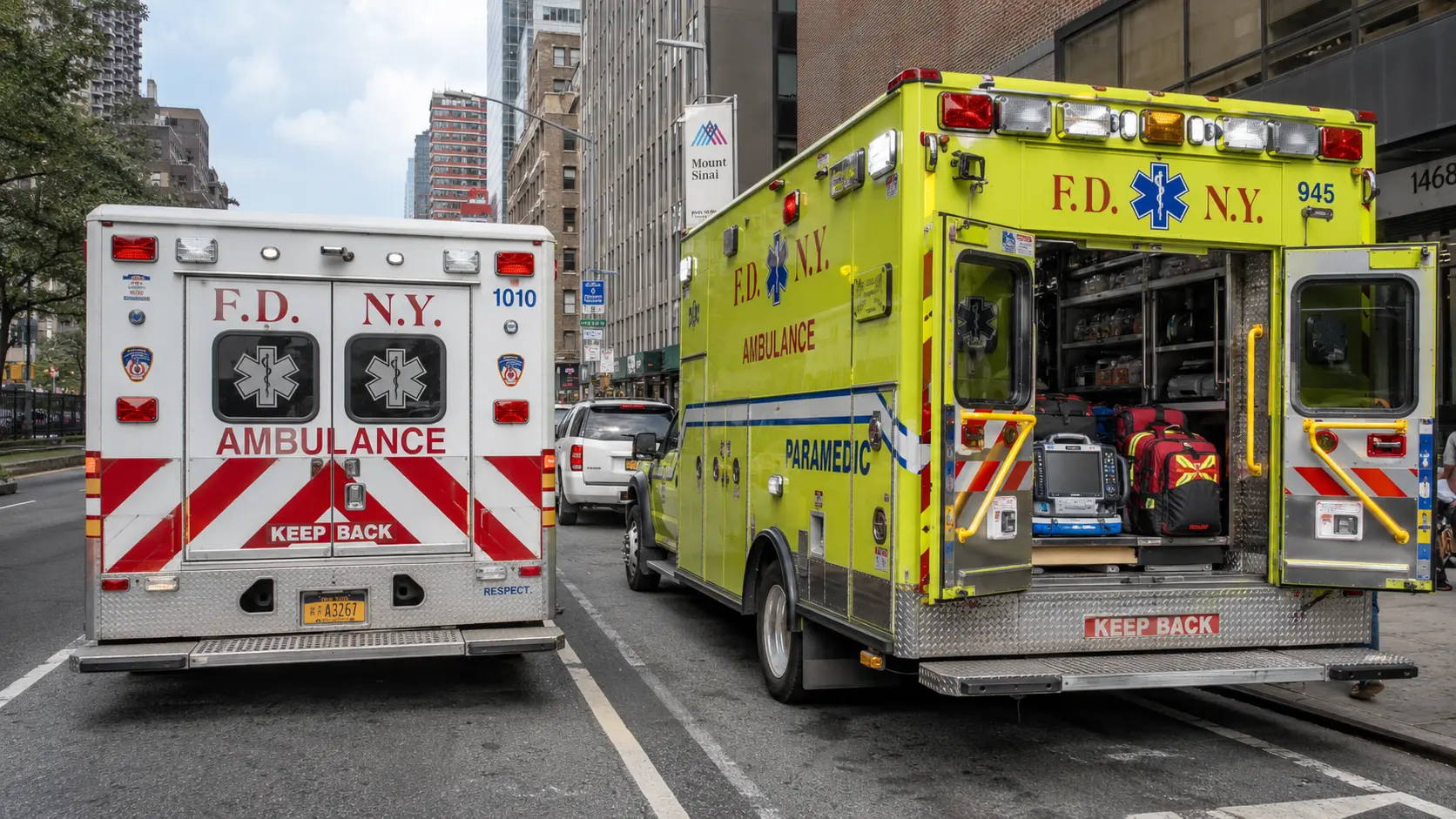 Paramedics performing resuscitation on a patient at a city sidewalk emergency scene.