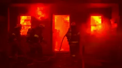 Firefighters battling a fierce blaze in a residential area of Owensboro, smoke billowing into the sky.